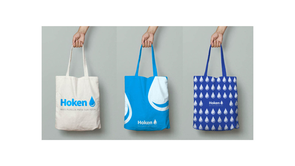 Three Hoken tote bags in white, blue and patterned navy with the water-drop logo.