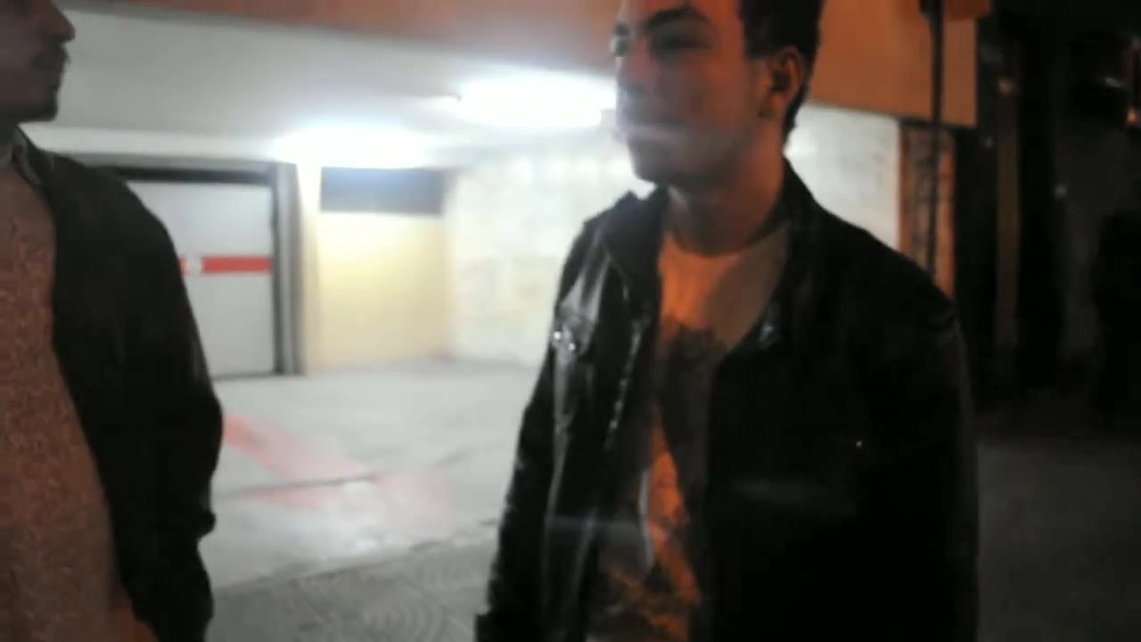 Dos amigos conversando en la entrada de un garaje en el centro de São Paulo
